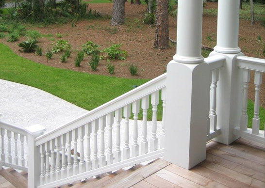 A white railing on a wooden deck, providing safety and adding a touch of elegance to the outdoor space.