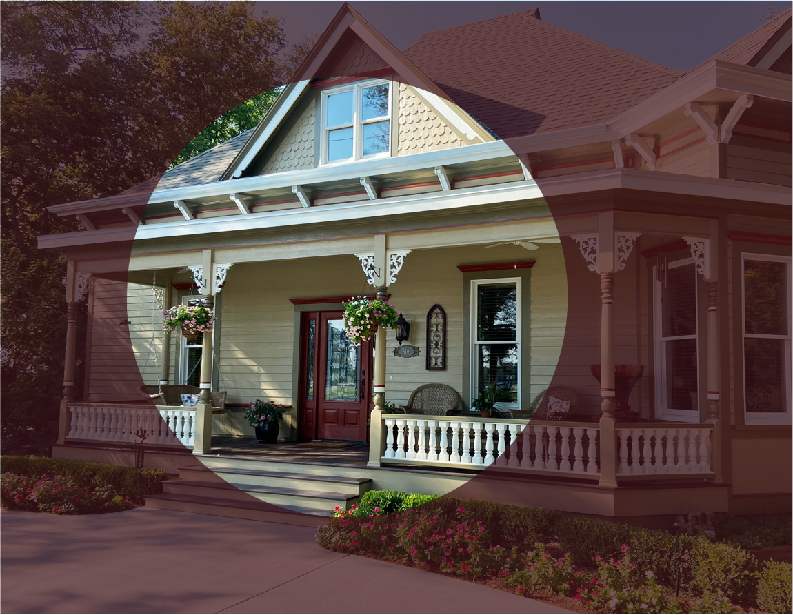 A house with a porch and a front porch, surrounded by greenery and a well-maintained garden.